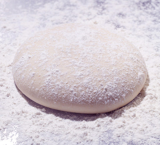 白い小麦粉に包まれた形成前丸いのピザ生地